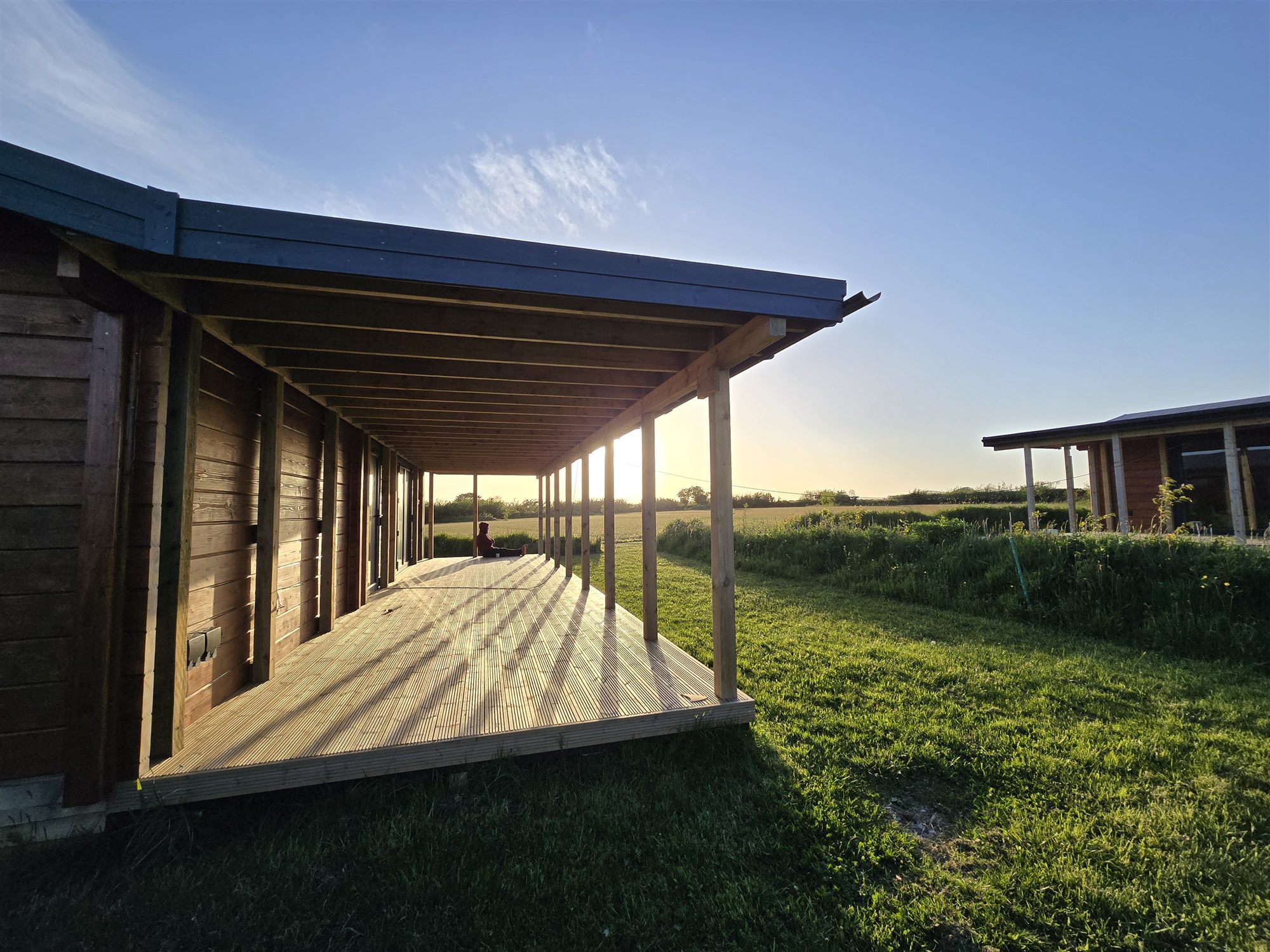 A timber lodge with a covered veranda in evening light.